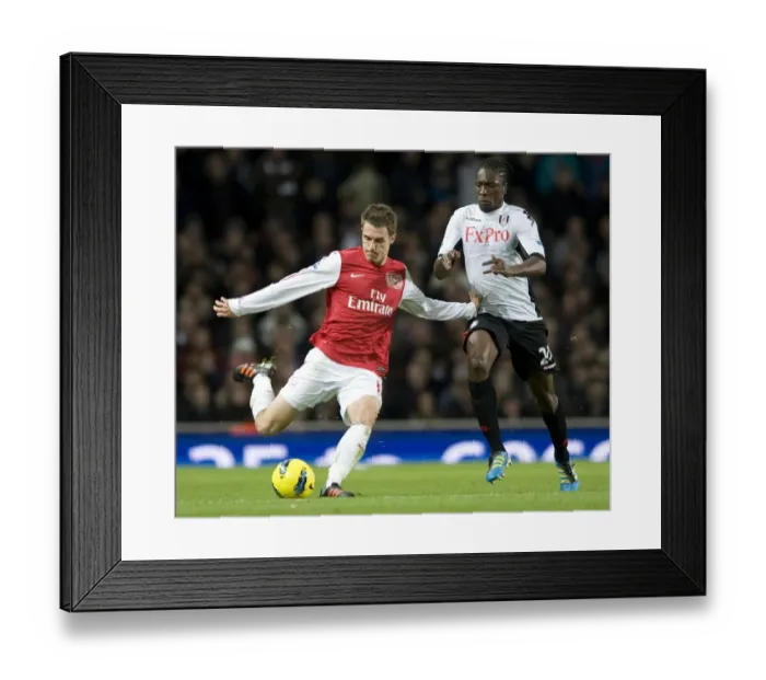 Framed Print : Aaron Ramsey of Arsenal takes on Dickson Etuhu of Fulham during the Barclays Premier League match between Arsenal and Fulham at Emirates Stadium on November 26, 2011 in London, England. Credit; Arsenal