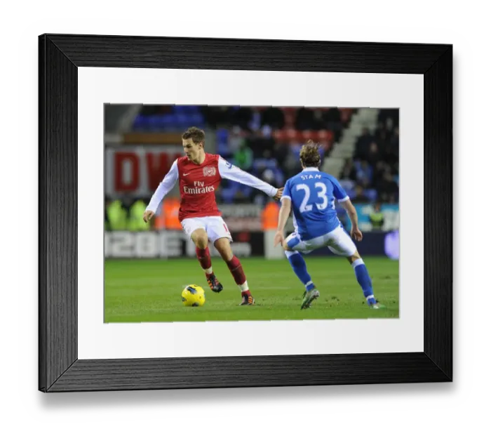 Framed Print : Arsenal's Aaron Ramsey Outmaneuvers Wigan's Ronnie Stam in Premier League Clash (December 2011)