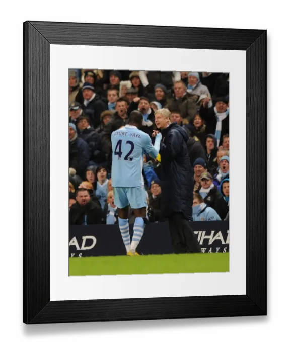 Framed Print : Wenger and Toure: A Light-Hearted Moment Amidst the Manchester Rivalry (2011-12)