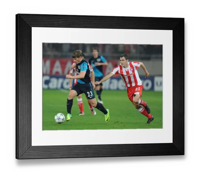 Framed Print : Andrey Arshavin vs. Pablo Orbaiz: Battle in the UEFA Champions League between Olympiacos and Arsenal