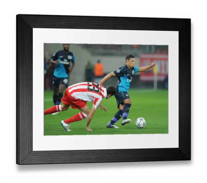Framed Print : Alex Oxlade-Chamberlain vs Ivn Marcano: Battle in the UEFA Champions League between Olympiacos and Arsenal