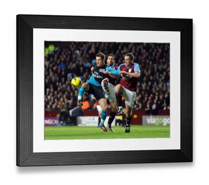 Framed Print : Aaron Ramsey Faces Off Against Carlos Cuellar and Richard Dunne in Intense Aston Villa vs. Arsenal Clash