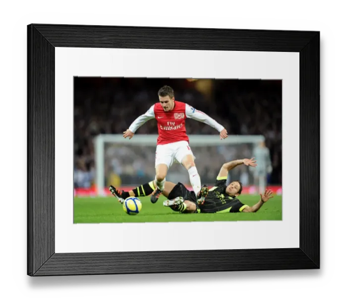 Framed Print : Arsenal's Aaron Ramsey Leaps Over Leeds Michael Brown in FA Cup Clash Framed Print : Arsenal's Aaron Ramsey Leaps Over Leeds Michael Brown in FA Cup Clash