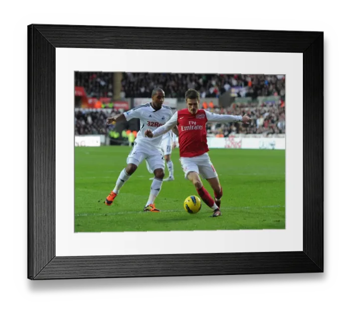 Framed Print : Arsenal's Aaron Ramsey Faces Off Against Swansea City's Kemy Agustien (2011-12)