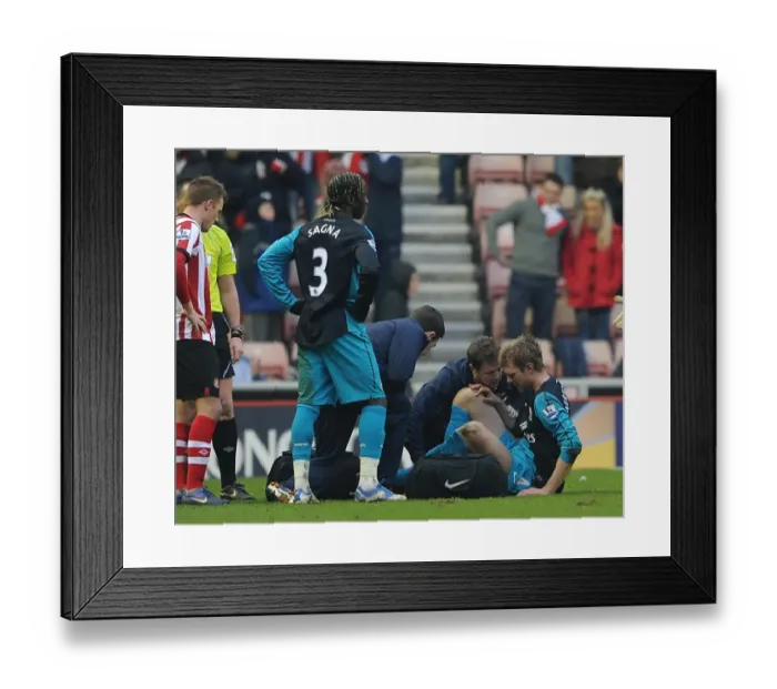 Framed Print : Per Mertesacker (Arsenal) is treated by Physio Colin Lewin. Sunderland 1: 2 Arsenal