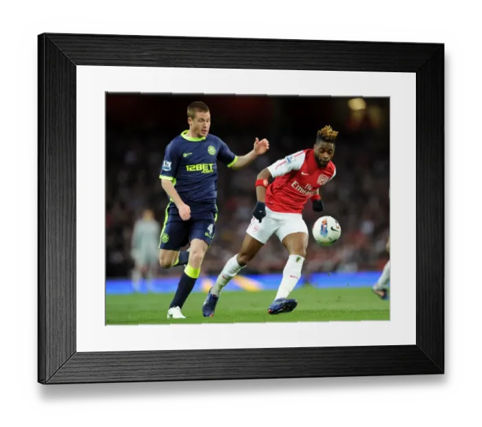 Framed Print : Arsenal's Alex Song Evades Wigan's James McCarthy Pressure in Premier League Clash Framed Print : Arsenal's Alex Song Evades Wigan's James McCarthy Pressure in Premier League Clash