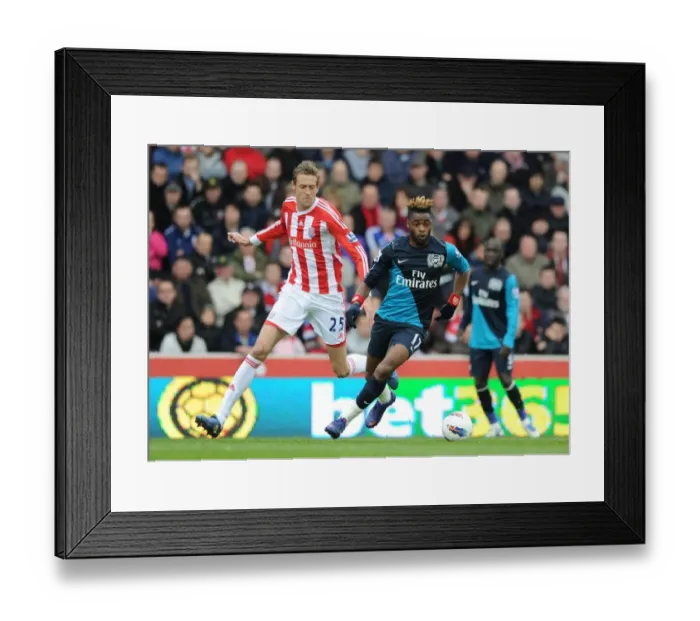 Framed Print : Alex Song Overpowers Peter Crouch: A Battle in the Premier League Clash Between Stoke and Arsenal Framed Print : Alex Song Overpowers Peter Crouch: A Battle in the Premier League Clash Between Stoke and Arsenal