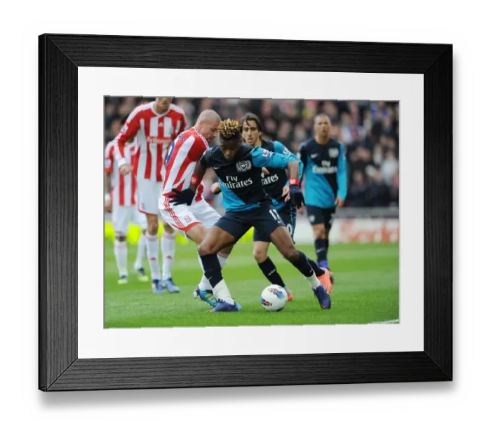 Framed Print : Alex Song Outmaneuvers Jonathan Walters: A Pivotal Moment in Stoke vs. Arsenal Premier League Clash