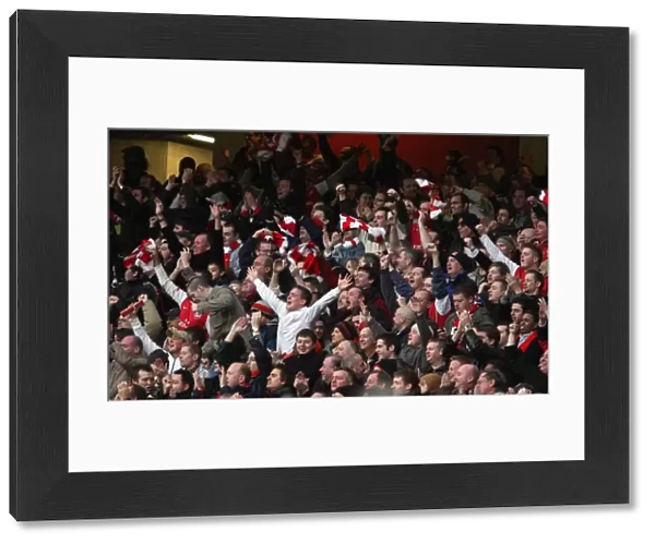 The Arsenal fans celebrate Emmanuel Adebayors 1st goal