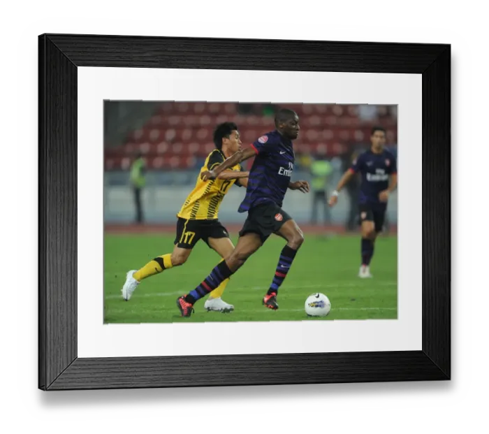 Framed Print : Abou Diaby vs Mohd Shakir Shaari: Clash in Kuala Lumpur - Arsenal FC vs Malaysia XI (2012) Framed Print : Abou Diaby vs Mohd Shakir Shaari: Clash in Kuala Lumpur - Arsenal FC vs Malaysia XI (2012)