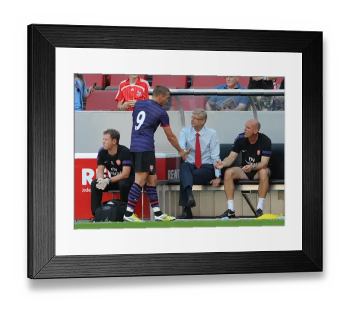 Framed Print : Arsene Wenger the Arsenal Manager shakes hands with Lukas Podolski as he comes of the pitch