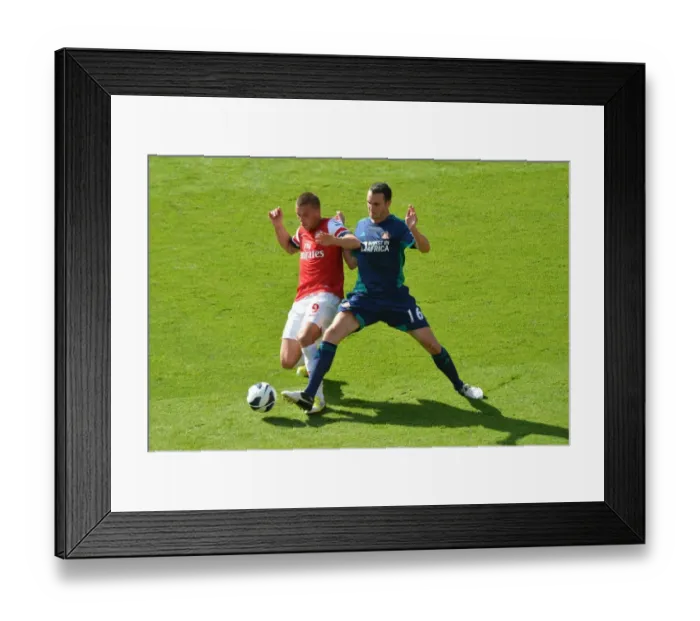 Framed Print : LONDON, ENGLAND - AUGUST 18: Lukas Podolski of Arsenal takes on John O Shea of Sunderland during the Barclays Premier League match between Arsenal and Sunderland at Emirates Stadium on August 18, 2012 in London, England. : Arsenal Football