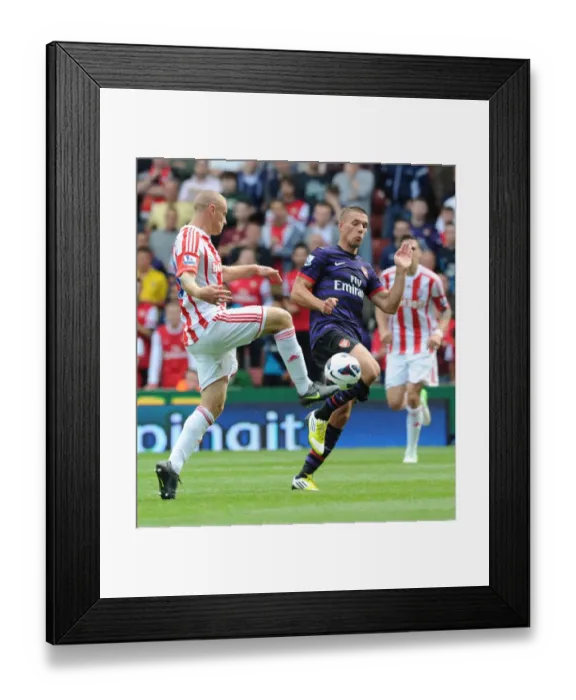 Framed Print : Podolski vs. Wilkinson: Intense Clash in Stoke City vs. Arsenal (2012-13) Framed Print : Podolski vs. Wilkinson: Intense Clash in Stoke City vs. Arsenal (2012-13)