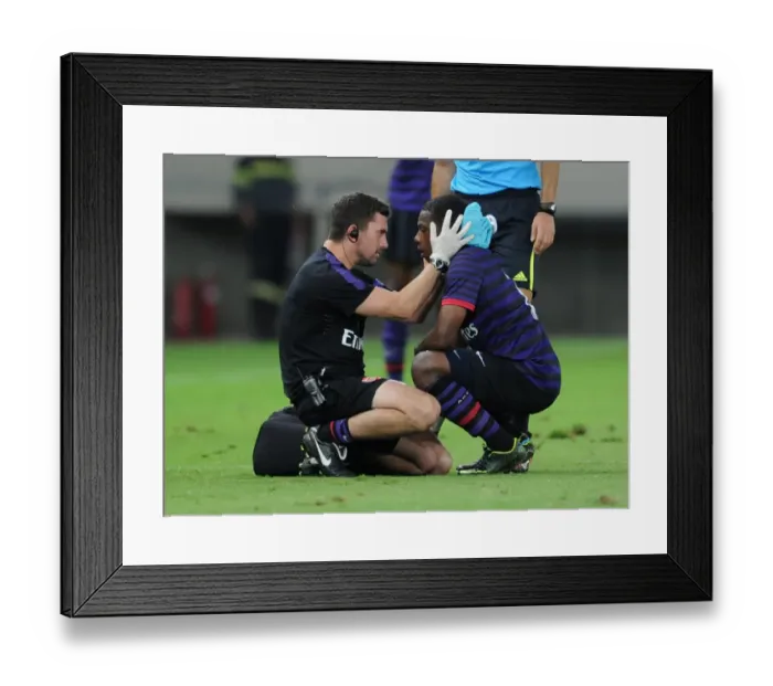Framed Print : Alastiar Thrush the Physio treats Anthony Jeffrey (Arsenal). Olympiacos U19 2: 0 Arsenal U19