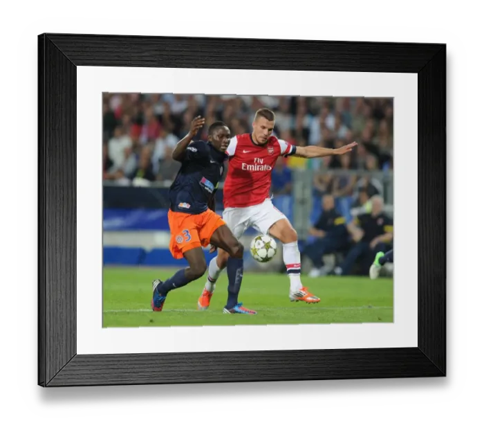 Framed Print : Podolski vs Yanga-Mbiwa: Battle in the UEFA Champions League