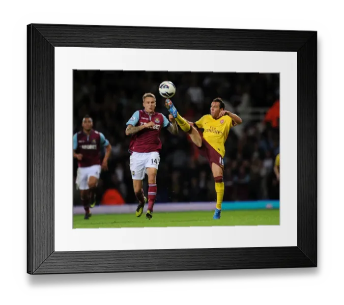 Framed Print : Santi Cazorla vs Matt Taylor: Intense Battle in West Ham United vs Arsenal Premier League Clash, 2012