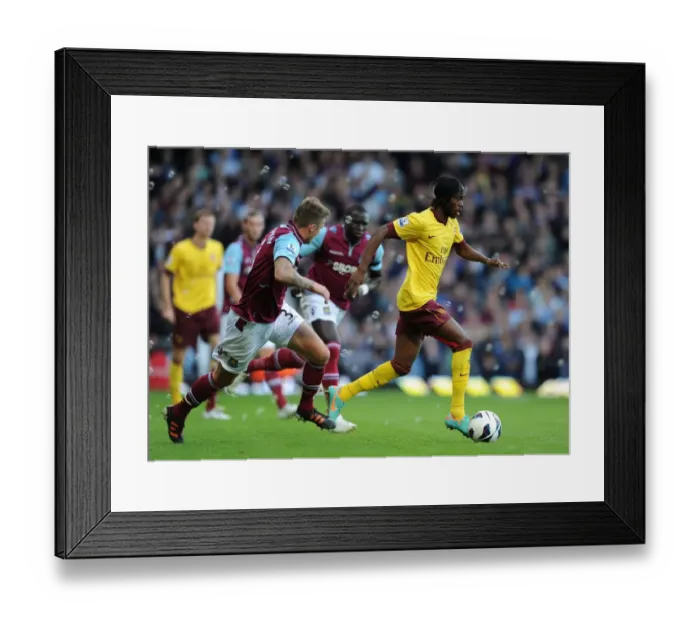 Framed Print : Gervinho vs. George McCartney: A Battle in the 2012-13 Premier League Clash Between West Ham and Arsenal