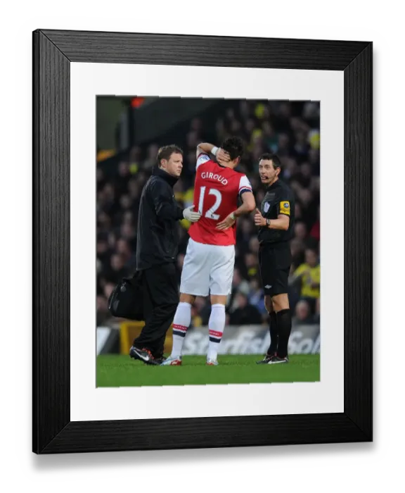 Framed Print : Arsenal's Olivier Giroud Receives Treatment from Physio Amidst Heated Norwich City Clash (2012-13)