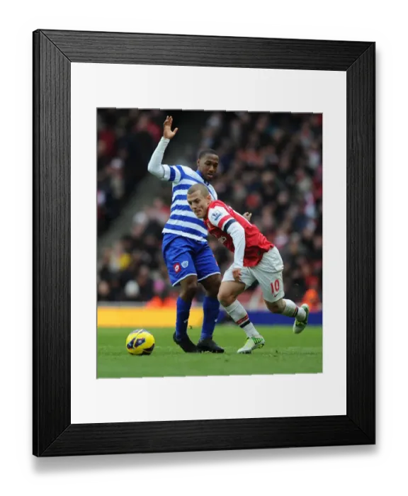 Framed Print : Arsenal's Jack Wilshere Outmaneuvers QPR's Junior Hoilett during the 2012-13 Premier League Match Framed Print : Arsenal's Jack Wilshere Outmaneuvers QPR's Junior Hoilett during the 2012-13 Premier League Match