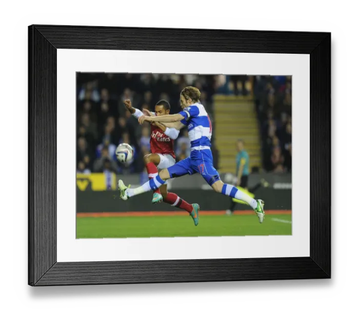 Framed Print : Theo Walcott vs Kaspars Gorkss: Intense Battle in Reading v Arsenal Capital One Cup Clash