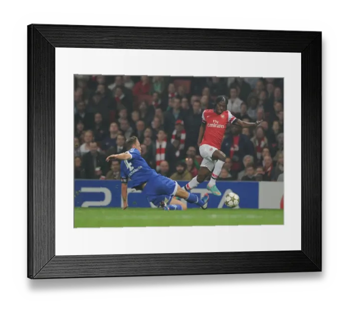 Framed Print : Arsenal's Gervinho Clashes with Schalke's Benedikt Howedes in 2012-13 Champions League Showdown