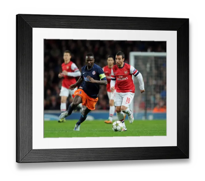 Framed Print : Arsenal's Santi Cazorla Clashes with Montpellier's Mapou Yanga-Mbiwa in UEFA Champions League Showdown