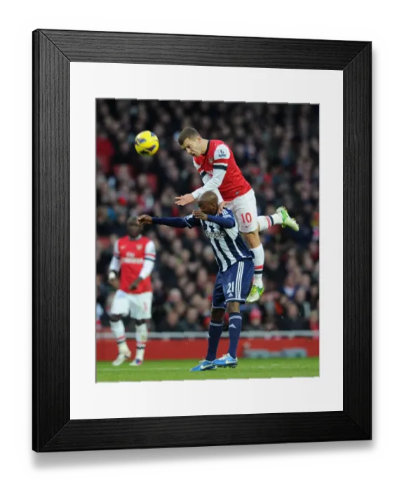 Framed Print : Arsenal's Jack Wilshere Leaps Over Youssouf Mulumbu (2012-13) Framed Print : Arsenal's Jack Wilshere Leaps Over Youssouf Mulumbu (2012-13)
