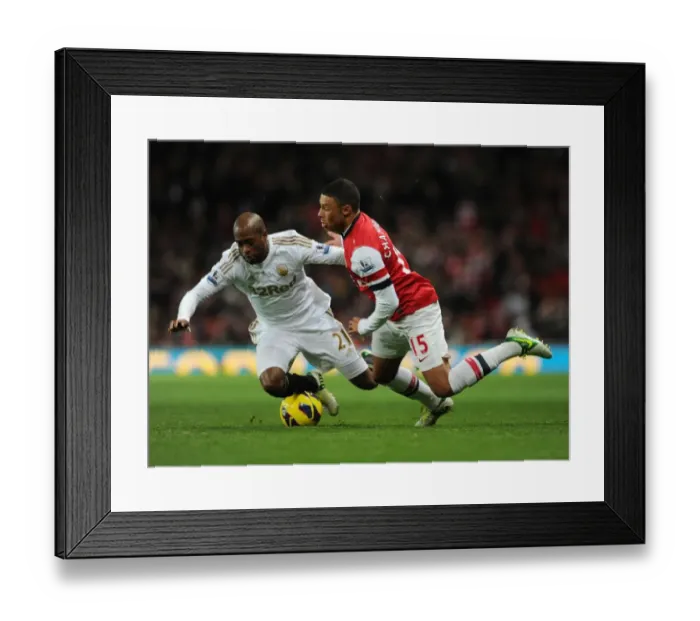 Framed Print : Arsenal's Alex Oxlade-Chamberlain Faces Off Against Swansea's Dwight Tiendalli in Premier League Clash