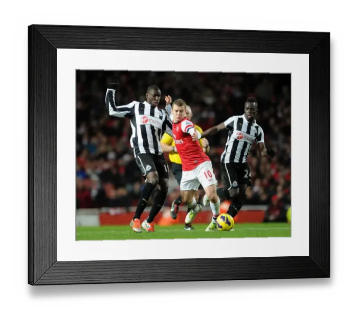Framed Print : Arsenal's Jack Wilshere Clashes with Newcastle's Ba and Tiote in Premier League Showdown