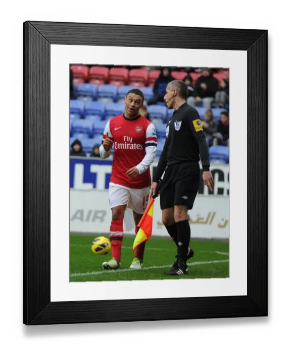Framed Print : Alex Oxlade-Chamberlain's Humorous Interlude: A Light-Hearted Moment Amidst Wigan Athletic vs Arsenal Tension (2012-13)