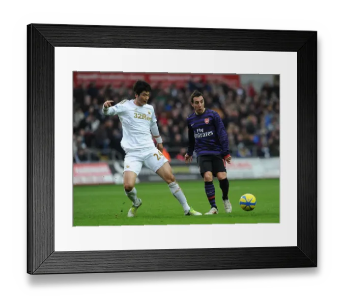 Framed Print : Clash of Midfield Maestros: Santi Cazorla vs. Ki Sung-Yueng (Swansea v Arsenal - FA Cup 3rd Round) Framed Print : Clash of Midfield Maestros: Santi Cazorla vs. Ki Sung-Yueng (Swansea v Arsenal - FA Cup 3rd Round)