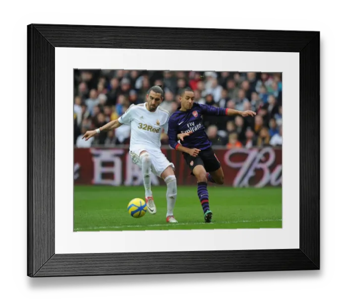 Framed Print : Theo Walcott vs Chico Flores: Intense Battle in Swansea v Arsenal FA Cup Match