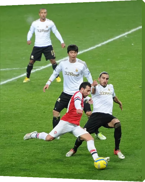 Santi Cazorla (Arsenal) shoots under pressure from Chico Flores and Sung-Yoeng Ki (Swansea)