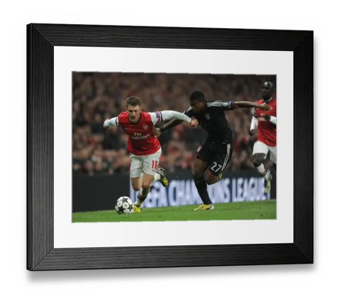 Framed Print : Arsenal's Aaron Ramsey Faces Off Against Bayern Munchen's David Alaba in Champions League Showdown Framed Print : Arsenal's Aaron Ramsey Faces Off Against Bayern Munchen's David Alaba in Champions League Showdown