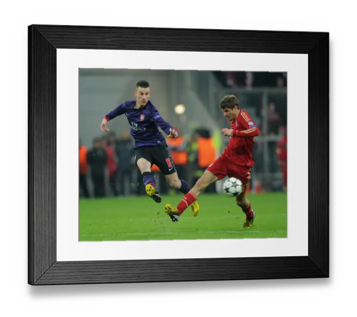 Framed Print : Koscielny vs. Muller: Intense Battle in Bayern Munich vs. Arsenal UEFA Champions League Clash Framed Print : Koscielny vs. Muller: Intense Battle in Bayern Munich vs. Arsenal UEFA Champions League Clash