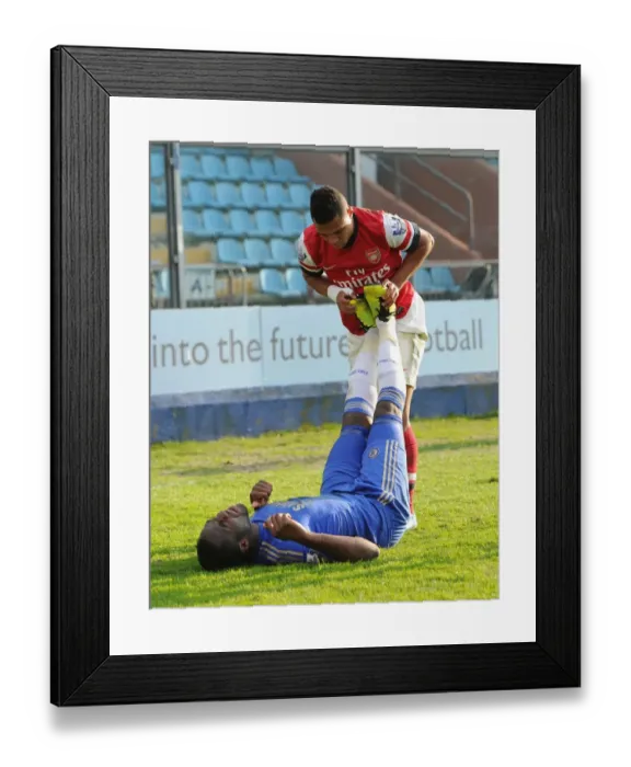 Framed Print : Serge Gnabry Shows Sportsmanship: Helping Injured Chelsea Player Danny Pappoe During Arsenal U19 vs Chelsea U19 NextGen Series Semi-Final