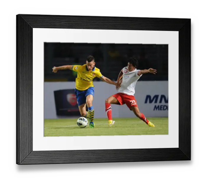 Framed Print : Arsenal's Laurent Koscielny Fends Off Indonesian Opponent During Pre-Season Match