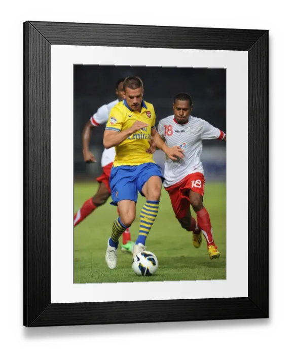 Framed Print : Lukas Podolski vs Yustinus Pae: Arsenal Star Clashes with Indonesia All-Star