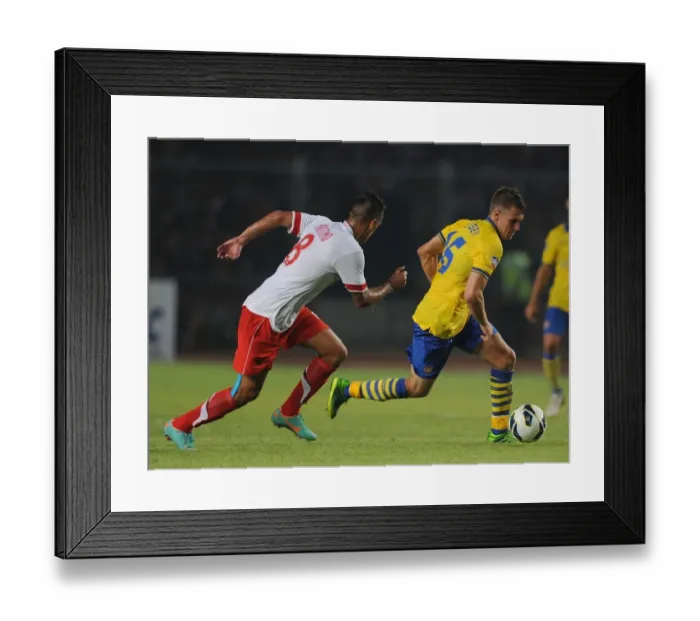 Framed Print : Arsenal's Aaron Ramsey Faces Off Against Raphael Maitimo of Indonesia Dream Team Framed Print : Arsenal's Aaron Ramsey Faces Off Against Raphael Maitimo of Indonesia Dream Team