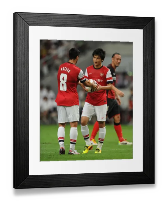 Framed Print : Mikel Arteta Assists Ryo Miyaichi in Pre-Season Penalty Shootout at Nagoya Grampus vs. Arsenal (2013)