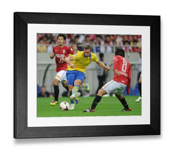Framed Print : Lukas Podolski vs. Yosuke Kashiwagi: A Battle for Ball Possession in Urawa Red Diamonds vs. Arsenal (2013)