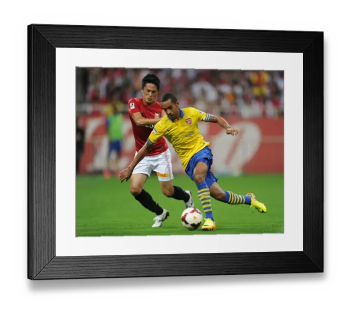 Framed Print : Theo Walcott vs. Kunimitsu Sekiguchi: A Battle for Ball Possession in Arsenal's Pre-Season Clash (2013)