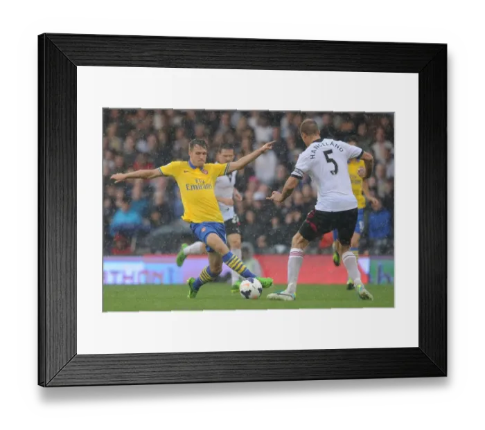 Framed Print : Arsenal's Aaron Ramsey Faces Off Against Fulham's Brede Hangeland in Premier League Clash Framed Print : Arsenal's Aaron Ramsey Faces Off Against Fulham's Brede Hangeland in Premier League Clash