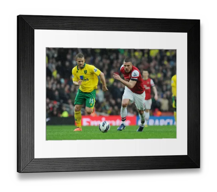 Framed Print : Arsenal's Lukas Podolski Outmaneuvers Norwich's David Fox in 2012-13 Premier League Clash Framed Print : Arsenal's Lukas Podolski Outmaneuvers Norwich's David Fox in 2012-13 Premier League Clash