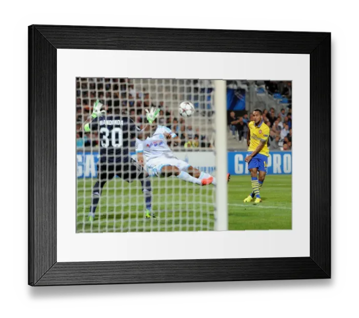 Framed Print : Theo Walcott Scores Against Mandanda: Arsenal Triumphs Over Marseille in Champions League Clash