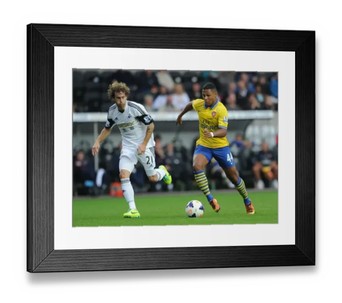Framed Print : Serge Gnabry vs Jose Canas: Intense Battle in Swansea City vs Arsenal Premier League Clash