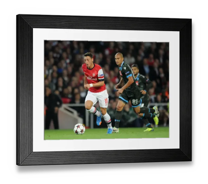 Framed Print : Mesut Ozil vs. Gokhan Inler: Battle in the Arsenal v Napoli UEFA Champions League Match