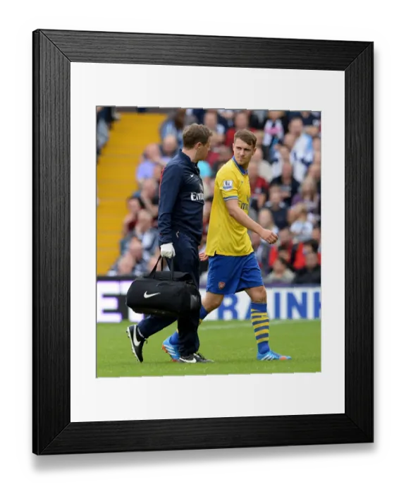 Framed Print : Arsenal's Aaron Ramsey Receives Treatment from Physio Colin Lewin during West Bromwich Albion Match