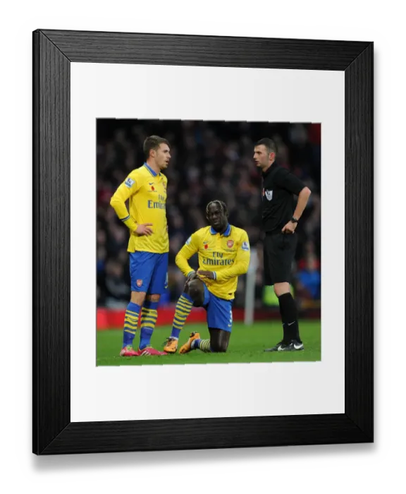 Framed Print : Arsenal's Sagna and Ramsey Confer with Referee Oliver during Manchester United Clash (2013-14) Framed Print : Arsenal's Sagna and Ramsey Confer with Referee Oliver during Manchester United Clash (2013-14)
