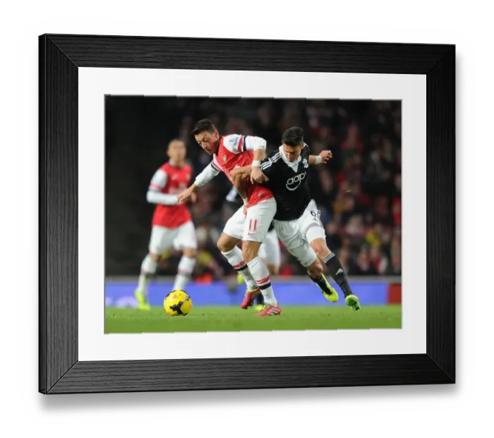Framed Print : Mesut Ozil vs Jose Fonte: A Footballing Battle at Arsenal vs Southampton (2013-14) Framed Print : Mesut Ozil vs Jose Fonte: A Footballing Battle at Arsenal vs Southampton (2013-14)